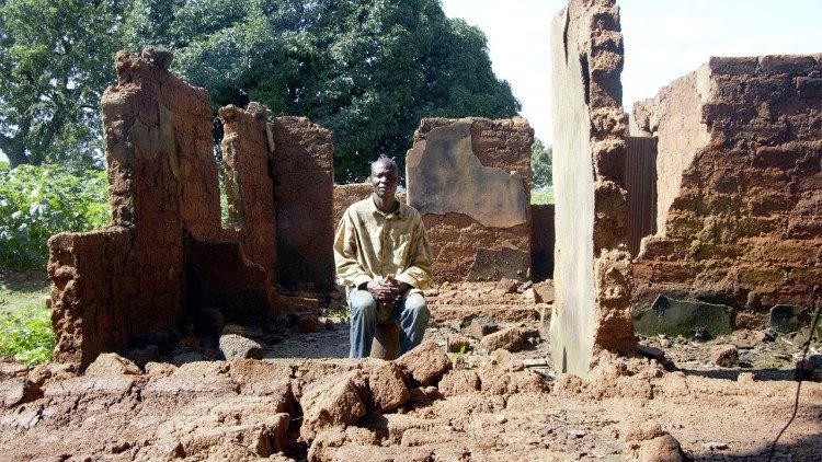 Il pastore di una chiesa davanti a ciò che rimane della sua casa distrutta dalla violenza dei fulani in Nigeria, foto Open Doors