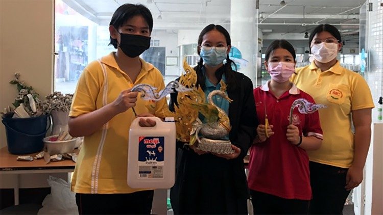 Refugees working for the waste recycling program show what they make out of plastic bottles