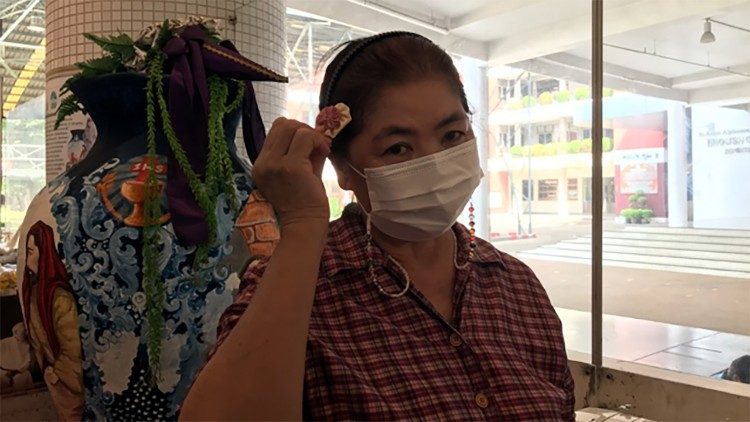 Refugee working for the waste recycling program demonstrating hair accessories she makes