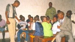 Floribert-seduto-a-destra-con-i-bambini-della-Scuola-della-Pace-di-Goma.jpg