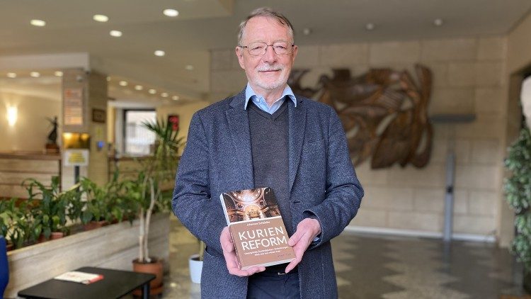 Der deutsche Vatikanjournalist Johannes Schidelko mit seinem Buch über die Kurienreform von Papst Franziskus