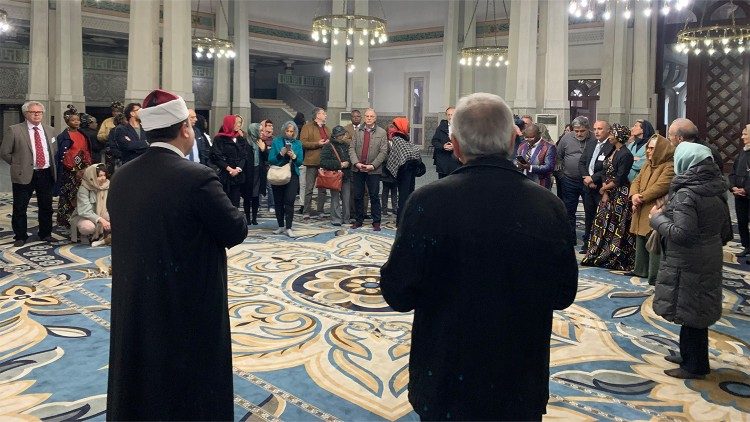 L'imam Nader Akkad (a sinistra di spalle) e don Giuliano Savina della Cei (a destra) nella sala di preghiera della Grande Moschea di Roma, insieme ai partecipanti all'incontro 