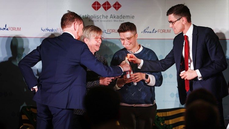 Im Bild: Michael Kretschmer (l) und Thomas Arnold (r) mit Diskussionsteilnehmern beim Entzünden der Hoffnungskerzen