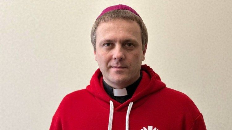Bp Aleksander Jaz?owiecki w bluzie Caritasu, poniewa? pos?uguje te? w tej organizacji