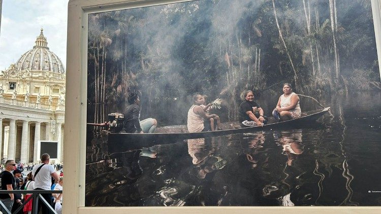 Exposição Fotográfica entre as colunas da Praça de São Pedro. Na fotografia, avó, mãe, tia e neta: mulheres que seguem para o cultivo de mandioca no coração da Amazônia