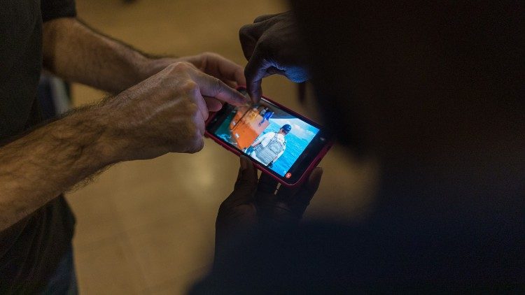 Roman Ebimene rivive attraverso le immagini del cellulare il momento in cui lui e altri tre nigeriani sono stati salvati dopo 14 giorni nascosti nella poppa di un cargo (Giovanni Culmone/Global Solidarity Fund).