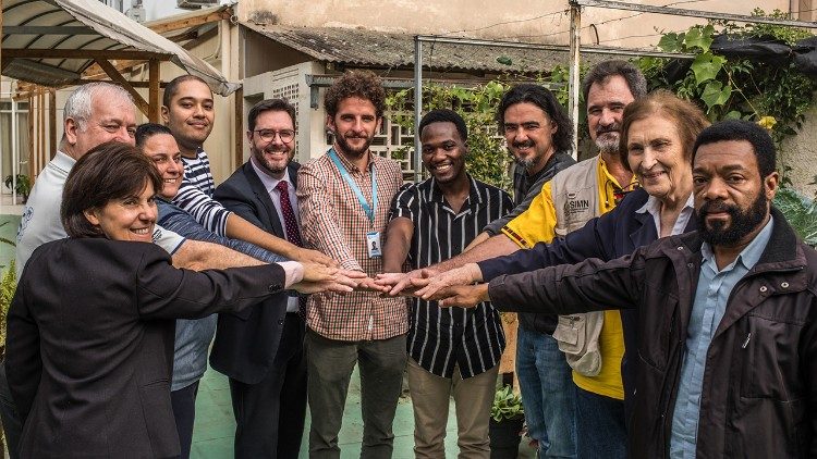 Narrador Kanhanga (al centro, con la camicia nera a strisce grigie) ha lasciato lAngola 18 anni fa e si è stabilito in Brasile. Oggi lavora a stretto contatto con altri esperti per rispondere in maniera efficace alle sfide che devono affrontare i migranti. (Giovanni Culmone/Global Solidarity Fund)