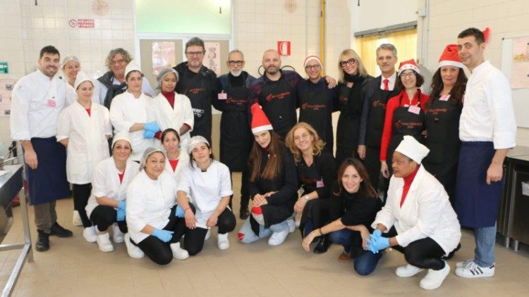 Il gruppo di cuochi e volontari del servizio ai tavoli, con vip e detenute. Grazia Schiavo è al centro, in ginocchio, con il cappello da Babbo Natale